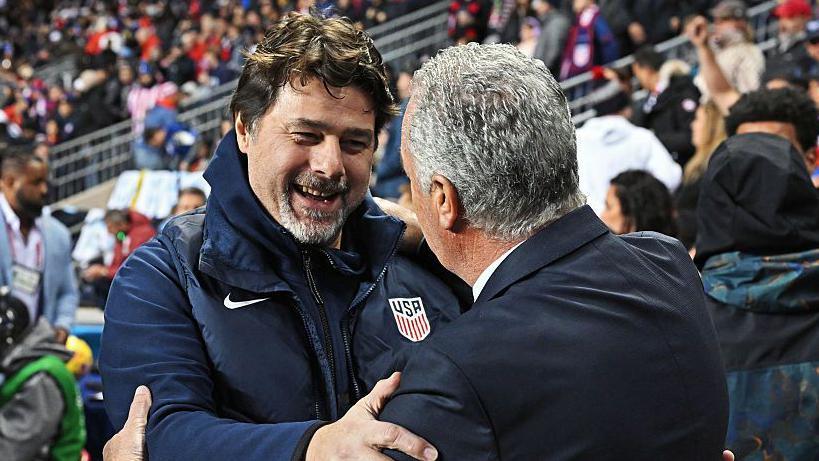 Mauricio Pochettino smiles on the touchline while wearing a USA tracksuit