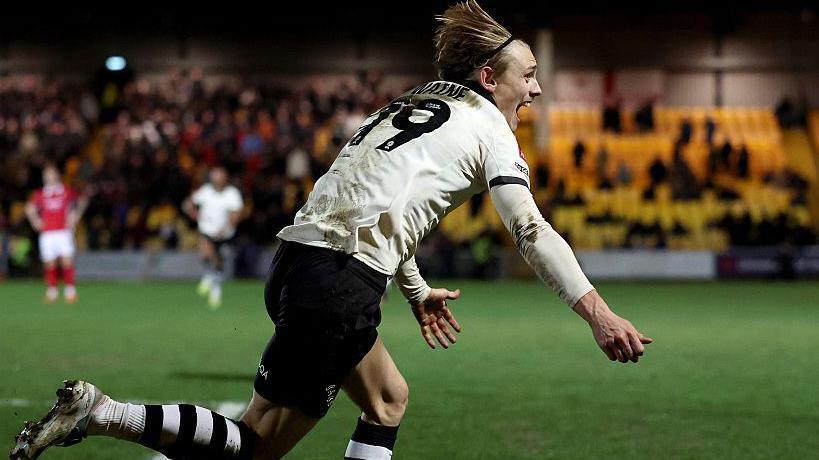 Ben Waine runs with his arms outstretched in front of him after scoring a goal