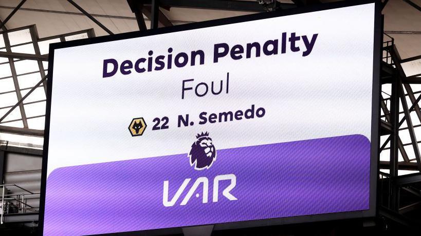 A screen in a stadium shows the outcome of a VAR check