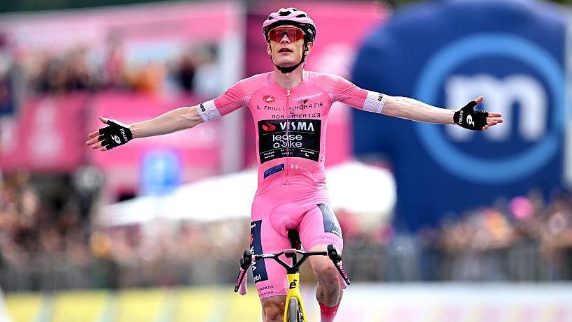 Jonas Vingegaard raises his arms as he crosses the finish line