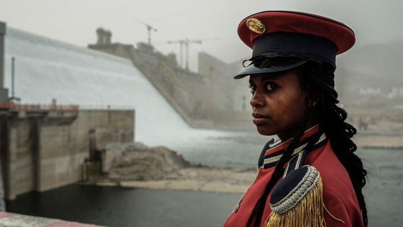 In red uniform, a member of Ethiopia's Republican March Band poses for a photo at the Grand Ethiopian Renaissance Dam (GERD) in Guba, Ethiopia, on 20 February 2022