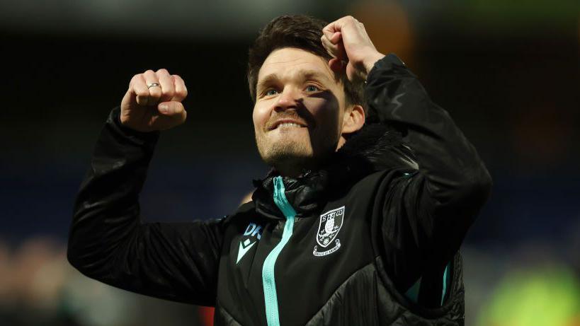 Sheffield Wednesday manager Danny Rohl punches the air with both fists to celebrate his team's win at Queen's Park Rangers