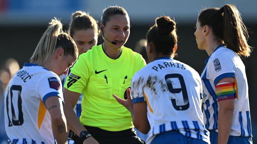 Brighton players surround the referee