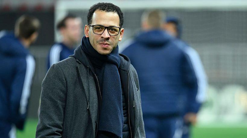 Liam Rosenior smiling and on the pitch while managing Strasbourg