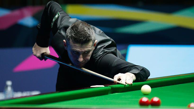 Mark Selby plays a shot