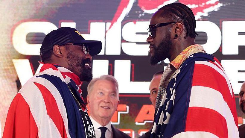 Derek Chisora and Deontay Wilder face off at a news conference draped in the flags of their country