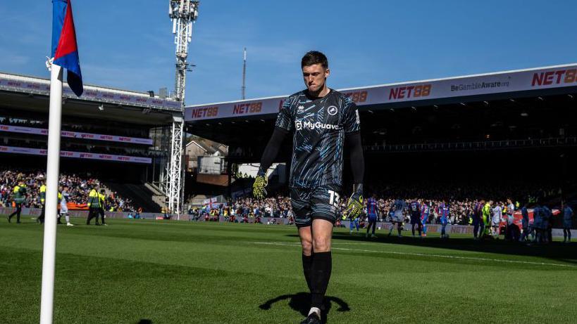 Millwall goalkeeper Liam Roberts walking off the pitch after being sent-off.