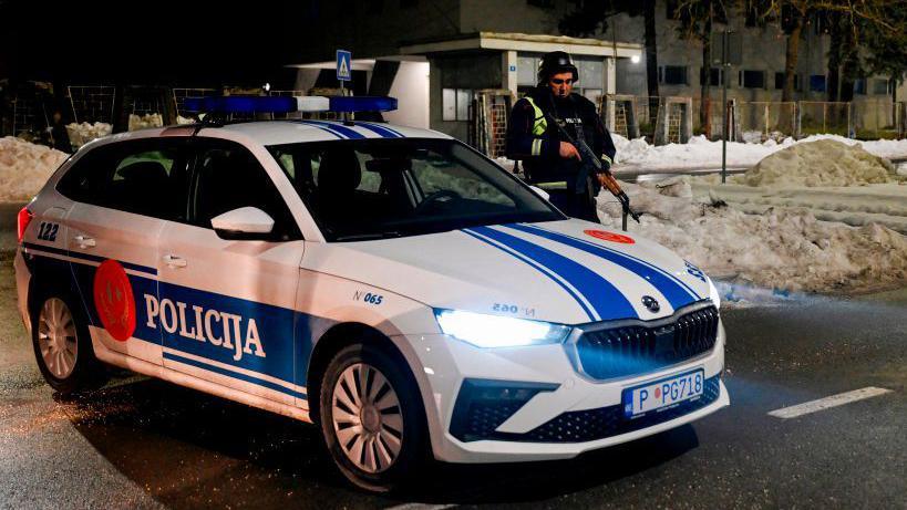 A police officer stands guard at a check point on the outskirts of Cetinje, on January 1, 2025, after a gunman killed several people in the nearby village of Bajice