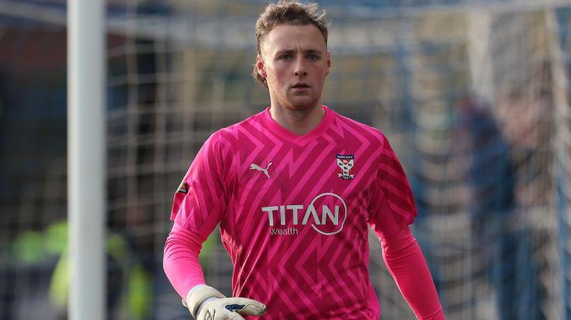George Sykes-Kenworhy wearing a pink York City goalkeeper's kit