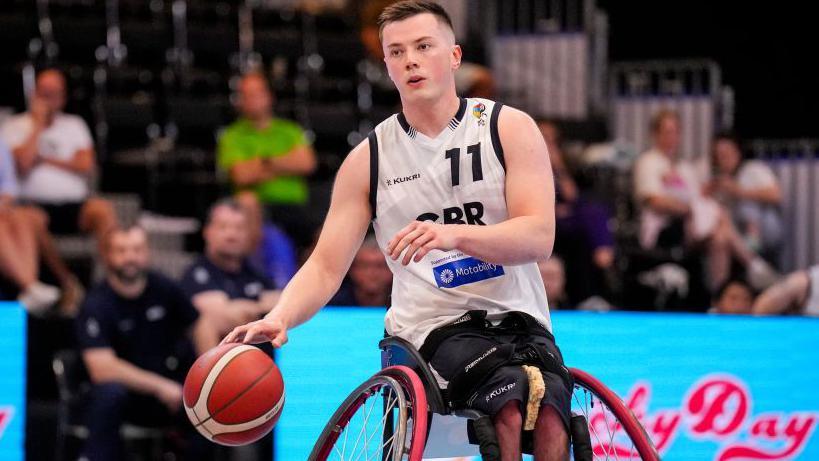 Wheelchair basketball player Phil Pratt bounces the ball