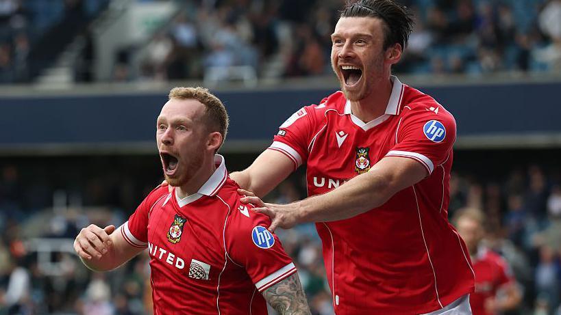 Lewis O'Brien (left) and Kieffer Moore celebrate Wrexham's win at Millwall