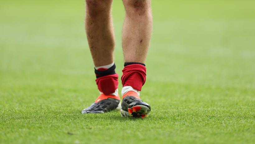 A football player wearing small shin pads