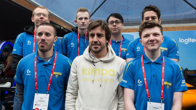 Sebastian Job standing next to Fernando Alonso after signing for his esports team