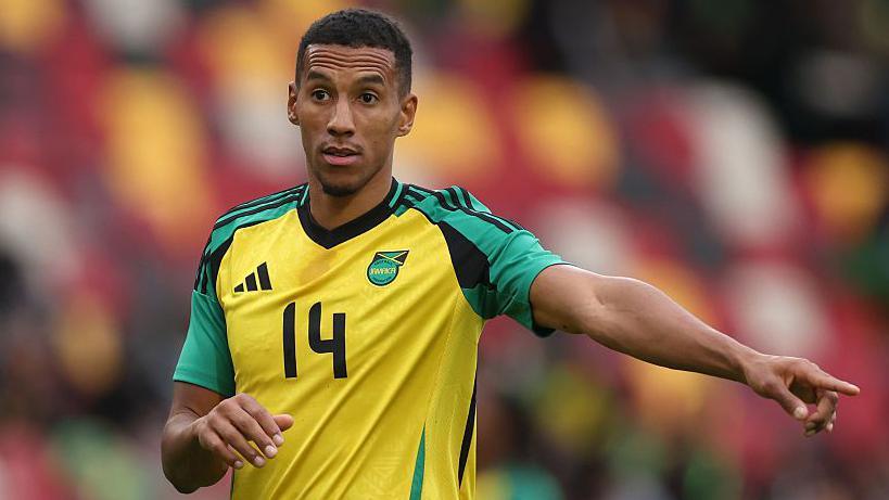 Isaac Hayden points while playing for Jamaica