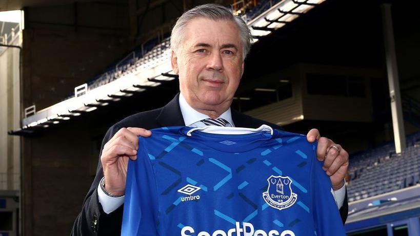 Carlo Ancelotti holding an Everton shirt