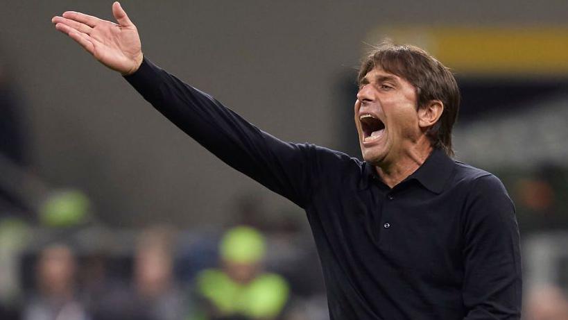 Antonio Conte waves his hand and shouts from the touchline