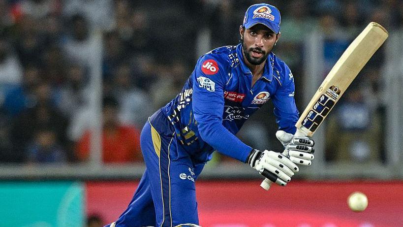 Tilak Varma watches the ball as he hits it through mid-wicket during an IPL game
