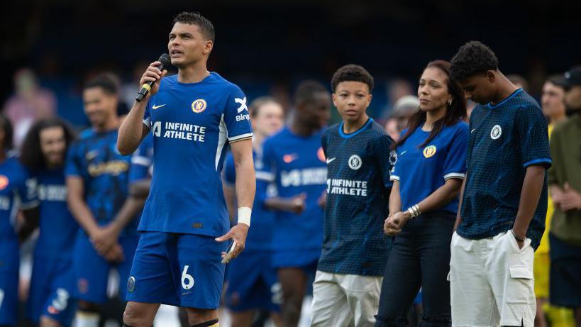 Thiago Silva doing a speech after his final home game at Chelsea with his family standing behind him, including son Isago