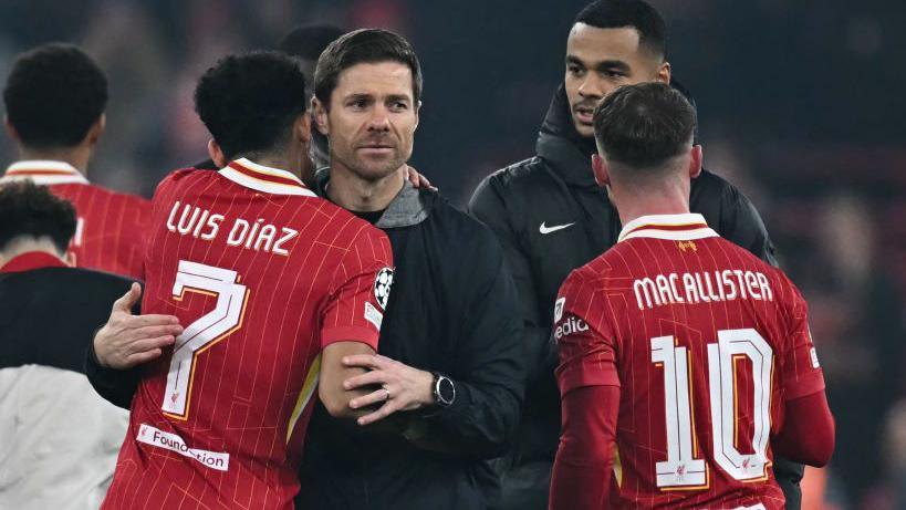 Liverpool's players console Bayer Leverkusen coach Xabi Alonso as his return to Anfield ends in Champions League defeat