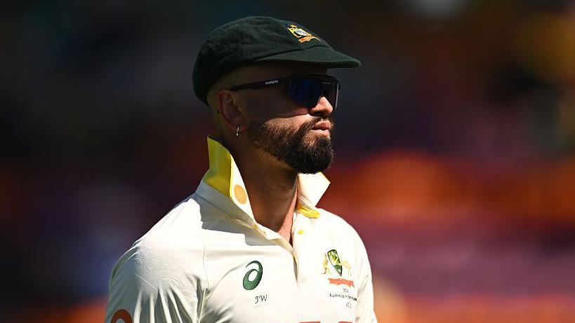 Australia's Jake Weatherald in the field during a Test match. He is wearing his baggy green cap, sunglasses and has the collars of his white shirt turned up.