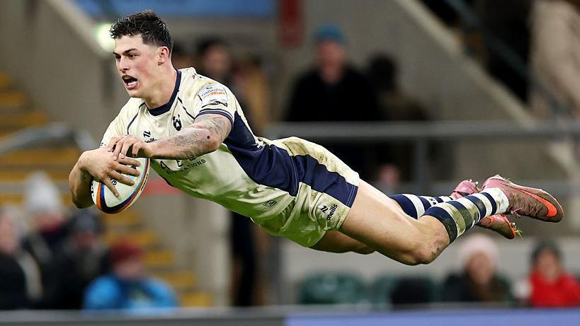 Louis Rees-Zammit se lanza por el aire para anotar un try para los Bristol Bears