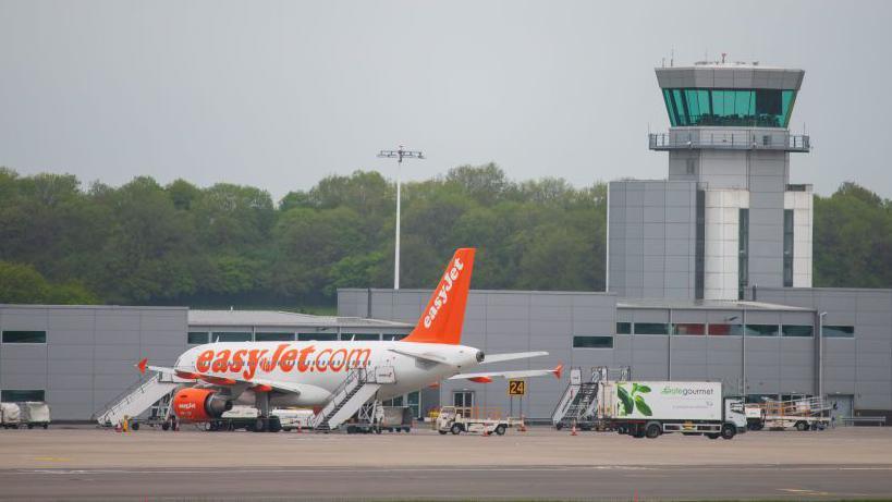A white and orange easyJet plane parked outside Bristol Airport.