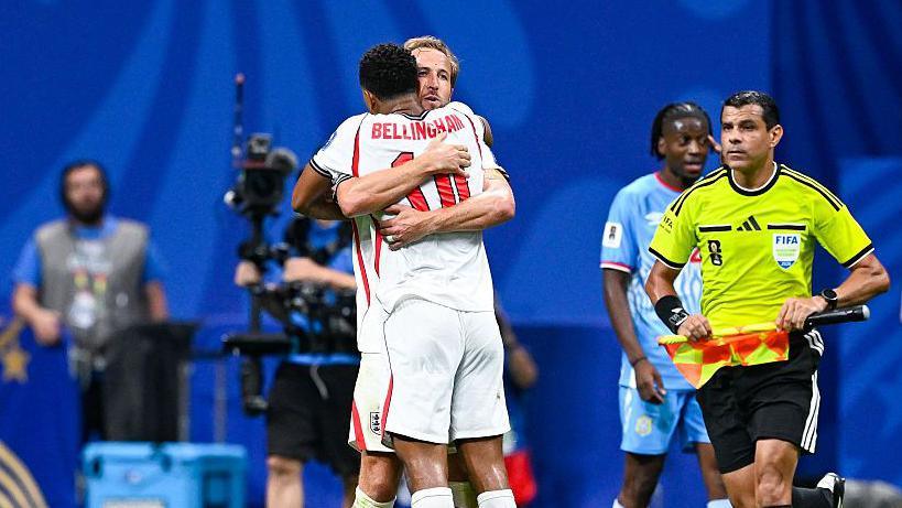 Harry Kane #9 of England embraces teammate Jude Bellingham #10.