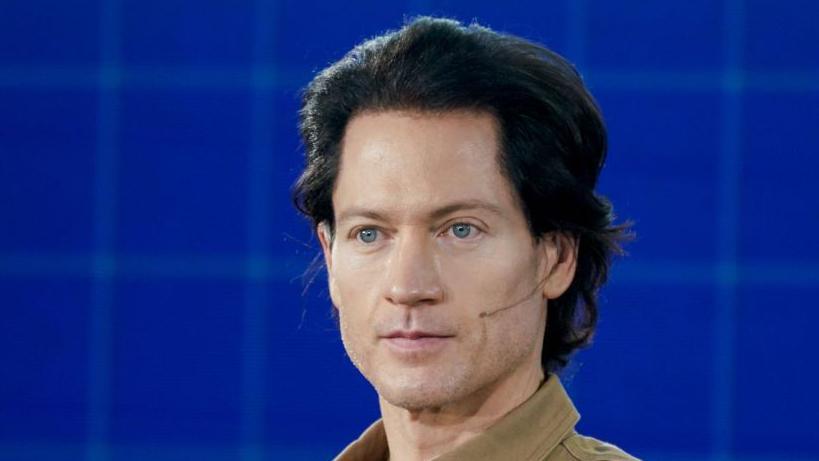Bryan Johnson at the Milken Institute Global Conference in Beverly Hills, California, in 2021. He has black hair and blue eyes.