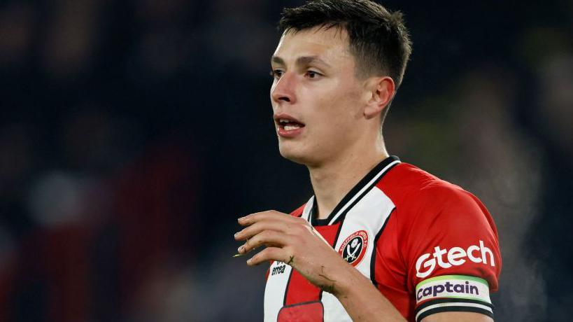 Anel Ahmedhodzic wears a standard captain's armband while playing for Sheffield United against Liverpool at Bramall Lane in the Premier League