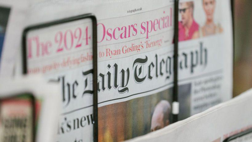 The Daily Telegraph, showing a 2024 Oscars special, being sold on a newspaper stand