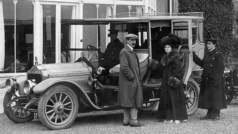 Violet Charlesworth standing next to a car with three men in 1900s