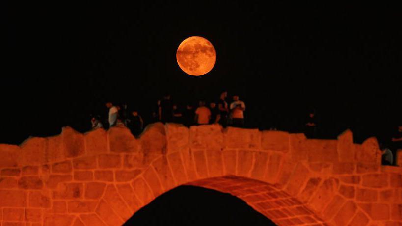 A red Supermoon above a red bridge in Iraq