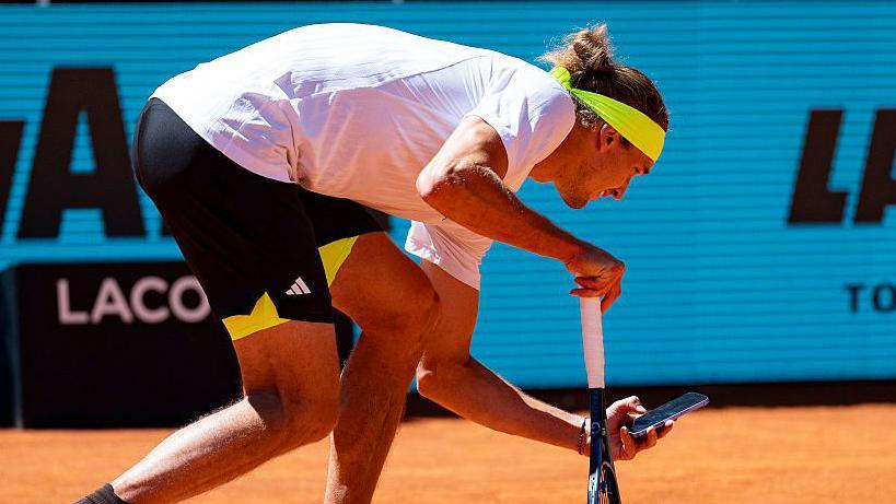 Alexander Zverev takes a photo of the disputed line call