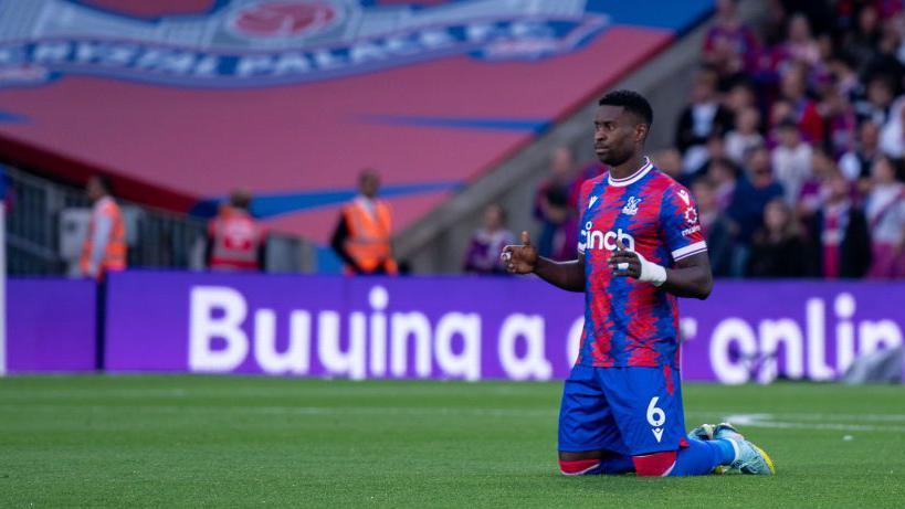 Marc Guehi kneels in prayer before a Premier League match in 2022