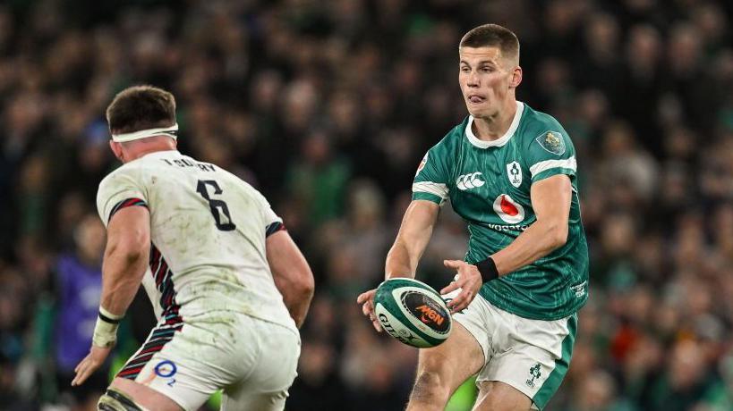 Sam Prendergast runs with the ball against England's Tom Curry 