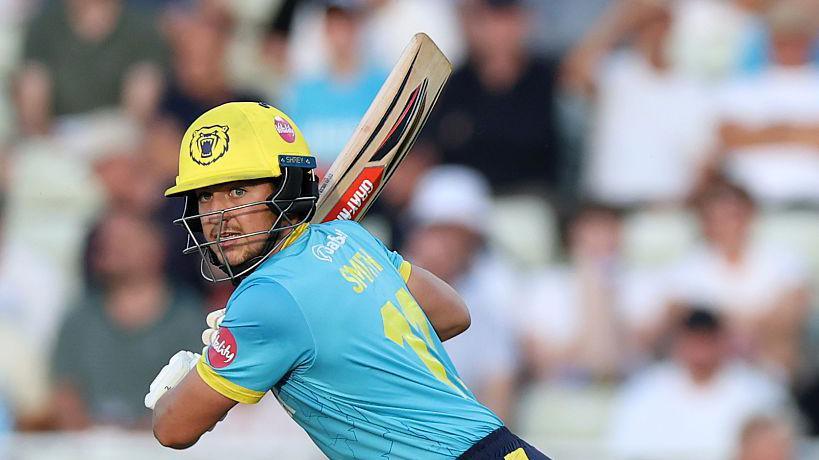 Kai Smith batting for Warwickshire in a yellow helmet and pale blue shirt