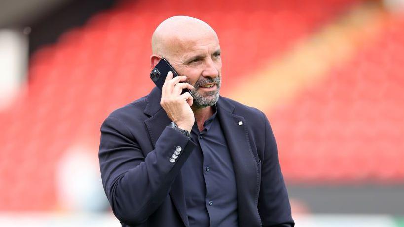 Monchi talks on a mobile phone