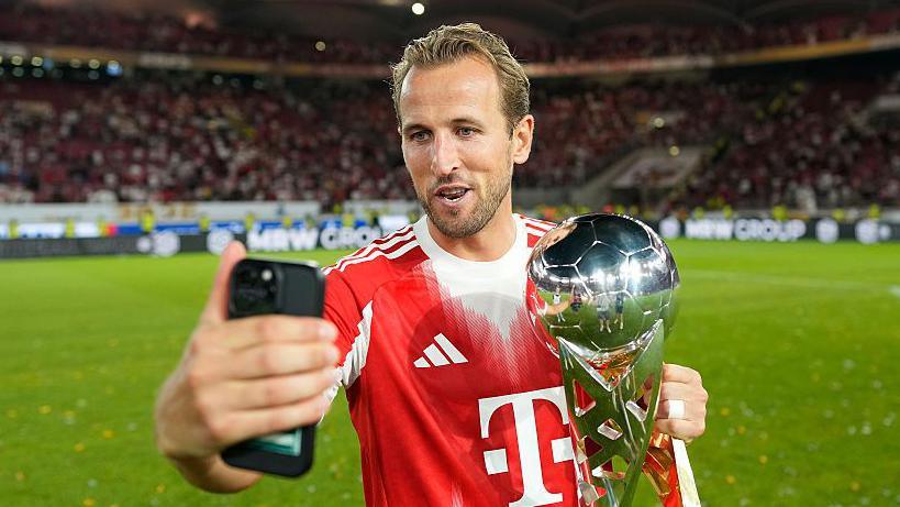 Harry Kane celebrates winning a trophy with Bayern Munich