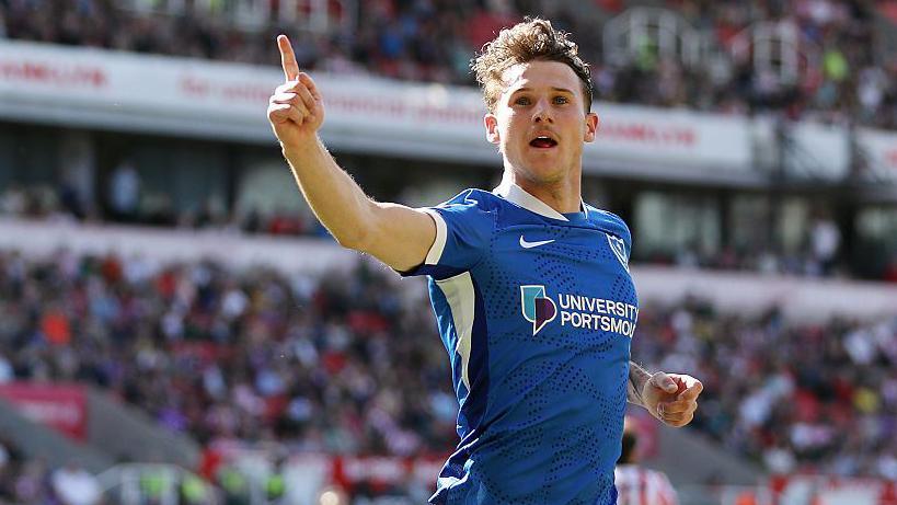 Portsmouth striker Adrian Segecic with his right arm raised with a finger pointing to the sky celebrates scoring a goal