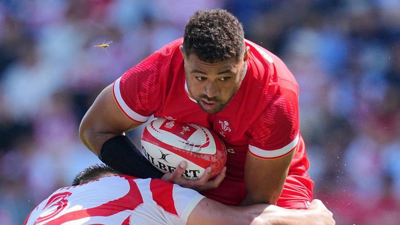 Wales number eight Taulupe Faletau is tackled by a Japan defender 