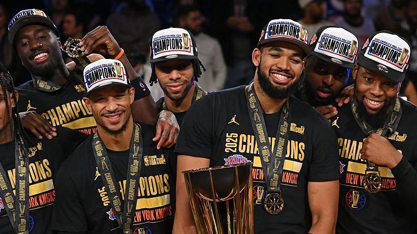 Karl-Anthony Towns holds the NBA Cup trophy besides his team-mates after the New York Knicks beat the San Antonio Spurs
