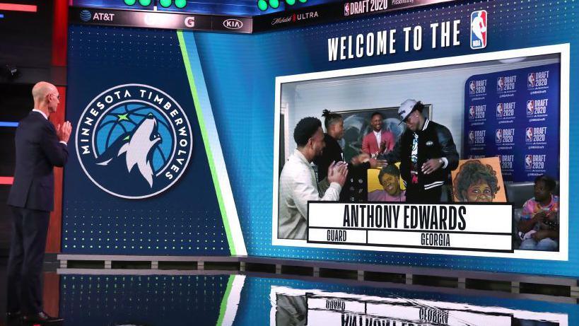 Anthony Edwards congratulated by his family as he's drafted number one in the 2020 NBA draft. He stands in front of two murals, one of his late mother and one of his late grandmother