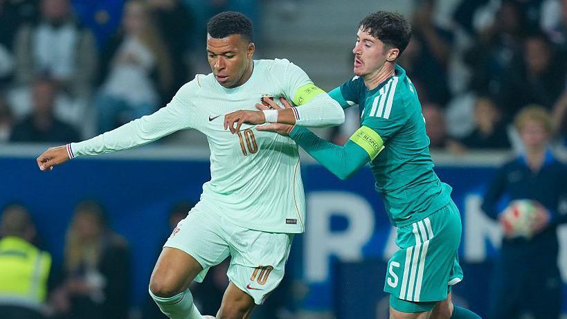 Kylian Mbappe is tracked by NI captain Trai Hume