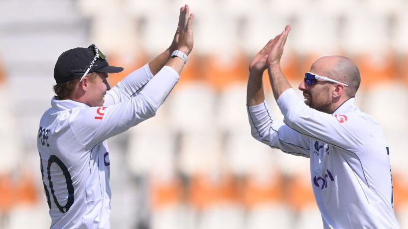 Ollie Pope and Jack Leach high five each other