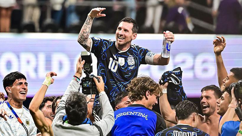 Lionel Messi carried by his Argentina team-mates