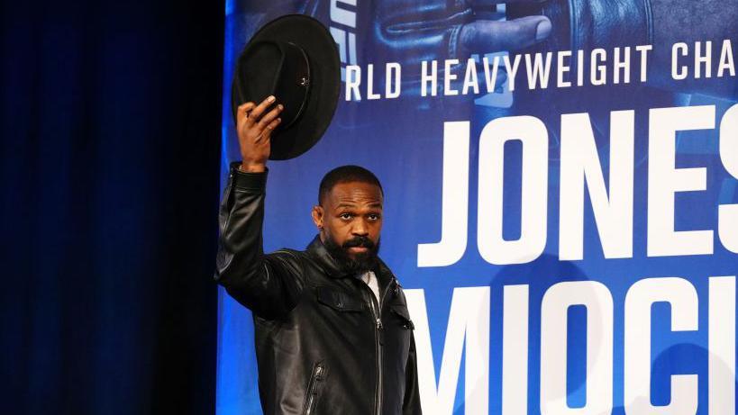 Jon Jones takes of his hat to the crowd as he appears on stage