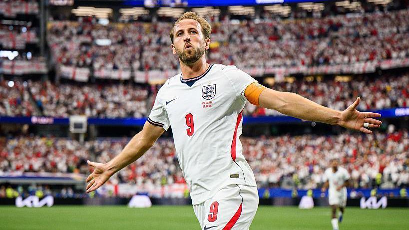 Harry Kane runs with his arms outstretched to celebrate a goal