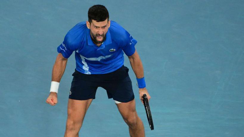 Novak Djokovic roars towards his team after beating Carlos Alcaraz at the Australian Open