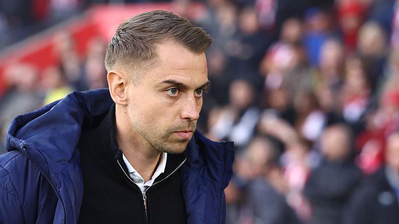 Southampton manager Tonda Eckert in blue coat and black zip-up top