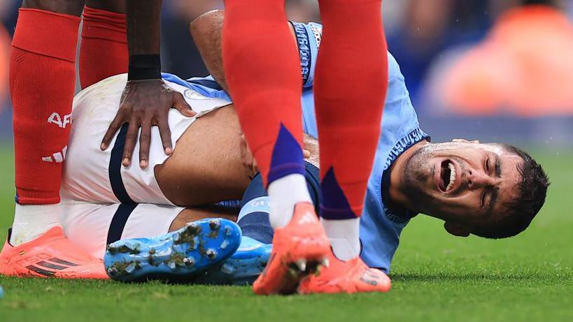 Manchester City's Rodri lying injured holding his leg